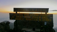 Gipfeltafel am Mount Meru, 4.566 m, Sonnenaufgang, der Kibo (Kilimanjaro) blitzt zwischen den Tafeln hervor; Tanzania
