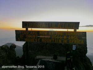 Gipfeltafel am Mount Meru, 4.566 m, Sonnenaufgang, der Kibo (Kilimanjaro) blitzt zwischen den Tafeln hervor; Tanzania